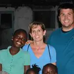 A family posing for a picture in front of some buildings.