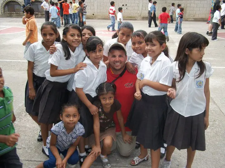 A group of children posing for a picture with a man.